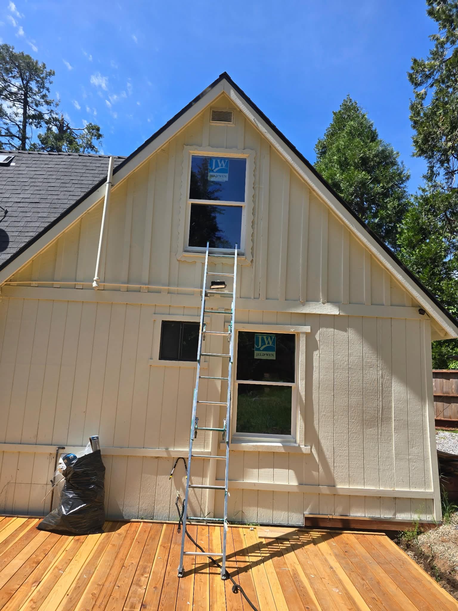 New windows installed on cabin gable end, fresh siding and deck