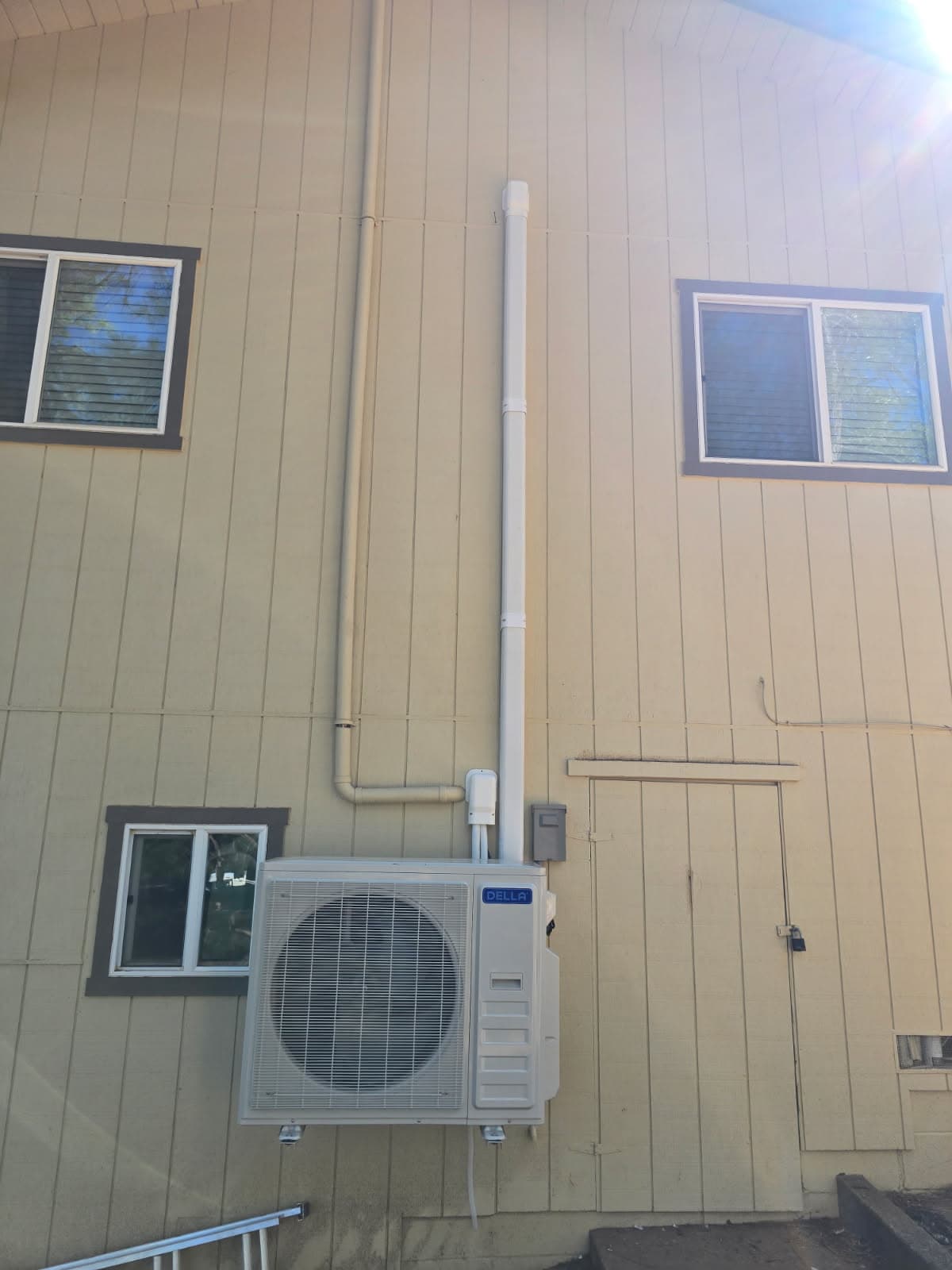 Mini-split condenser and line set mounted on a home's exterior wall